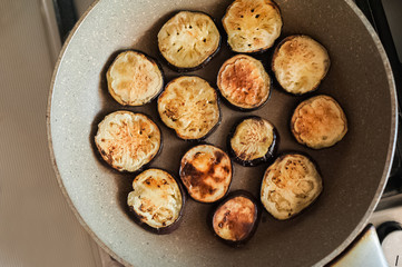  Sliced fried eggplant in a frying pan. Place for text.