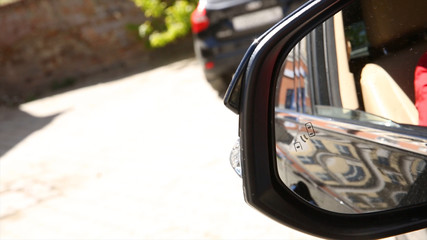 Blind Spot Monitoring system warning light icon in side view mirror of a modern vehicle. system...
