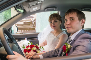 Bride and groom in a car in a wedding