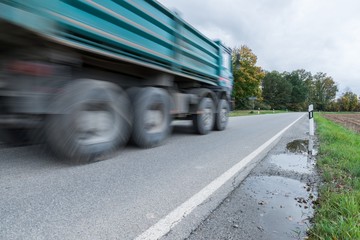 Vorbeifahrender Lastwagen auf einer Landstraße, Deutschland