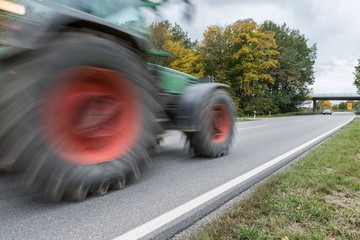 Vorbeifahrender Traktor auf einer Landstraße, Deutschland
