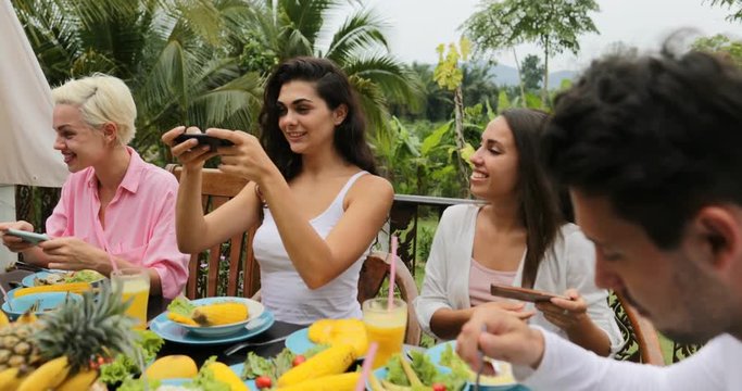 Girls Taking Photos Of Healthy Vegetarian Food On Cell Smart Phone, Friends Eating Talk Sitting On Tropical Terrace Slow Motion 60