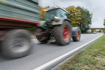 Vorbeifahrender Traktor auf einer Landstraße, Deutschland