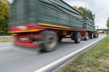 Fototapeta na wymiar Vorbeifahrender Traktor auf einer Landstraße, Deutschland