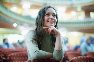 Portrait of  glad smiling woman satisfied theatre