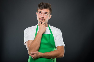 Portrait of attractive supermarket employer posing like thinking