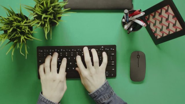 Top view shot of man typing fast on keyboard on a table with chroma key