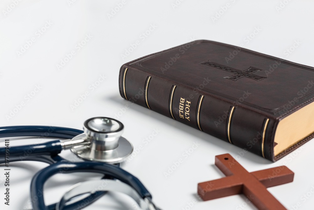 Wall mural bible with stethoscope on white