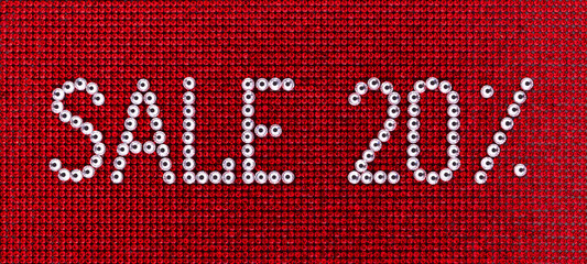 Word SALE is made rhinestones crystal color on a red canvas background.