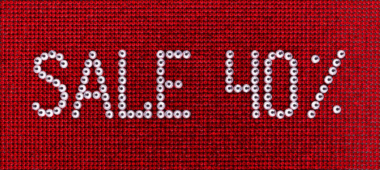 Word SALE is made rhinestones crystal color on a red canvas background.