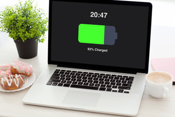 notebook with charged battery screen on desk in office