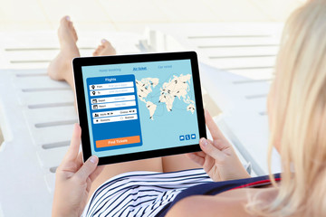 woman holding computer tablet with application search air ticket screen