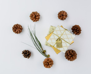 Christmas ornament golden gift boxes set and pine cones fresh green branch on white background,flat lay