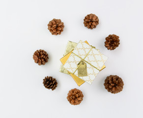 Christmas ornament golden gift boxes set and pine cones fresh green branch on white background,flat lay