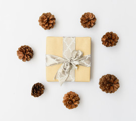 Christmas ornamate brown gift box and pine cones on white background,flat lay