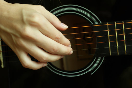  musician plays on a acoustic guitar