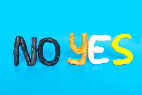 Choice concept, yes and no words made of modeling clay on the blue background.