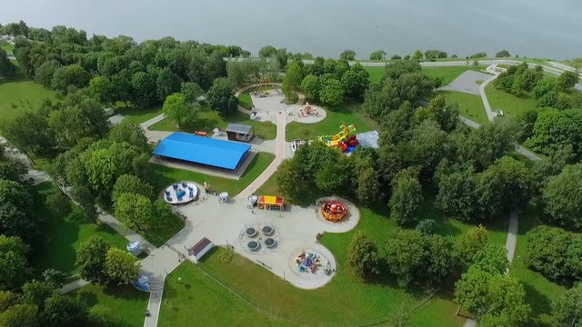 Summer, aerial view on a children's amusement park near the green trees. 

