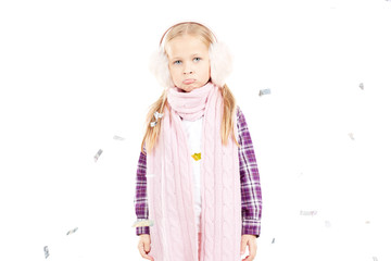 Portrait of little girl wearing scarf and winter ear muffs on white background
