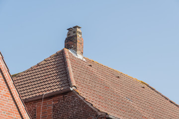 Schornstein auf einem Dach mit Dachpfannen 