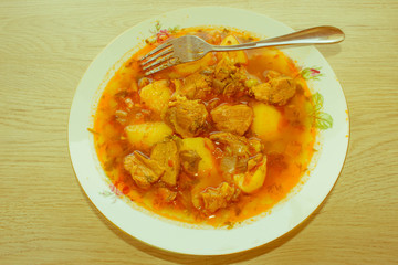 Tasty winter stew with meat and vegetables in bowl with ingredie
