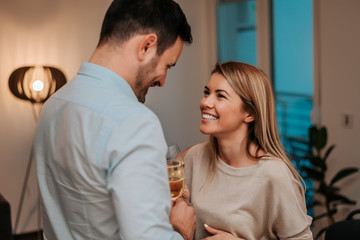 Happy couple drinking wine at home.