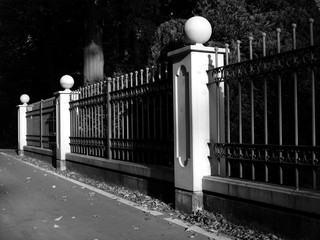 Prächtiger alter Zaun mit Steinsäulen um eine alte Villa im Herbst bei Sonnenschein in Schloß Holte-Stukenbrock bei Gütersloh in Ostwestfalen-Lippe, fotografiert in neorealistischem Schwarzweiß