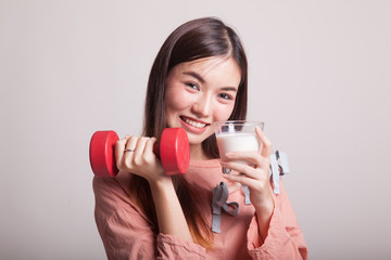 Healthy Asian woman drinking a glass of milk and dumbbell.