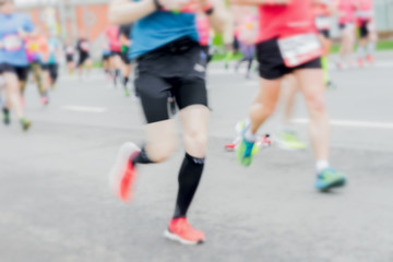 Close-up of feets, legs of runners, marathon on city streets. Abstract blurred sport background. Sport, fitness, healthy lifestyle