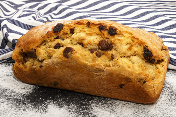 freshly baked raisin bread with flour on slate