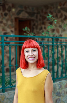 Smiling red heair girl standing at the front door