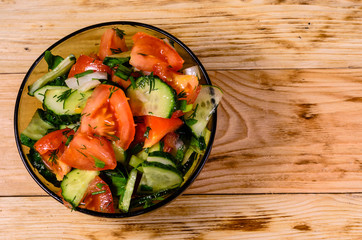 Salad with cucumbers and tomatoes on wooden table. Top view