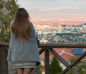 Chica con una bata caliente viento la ciudad por el balcon
