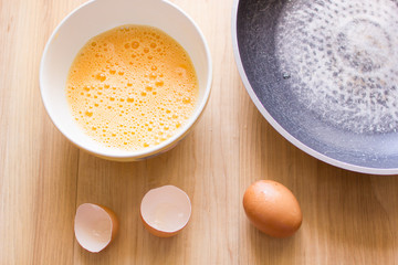 Fresh eggs in a cup and egg shell, pan