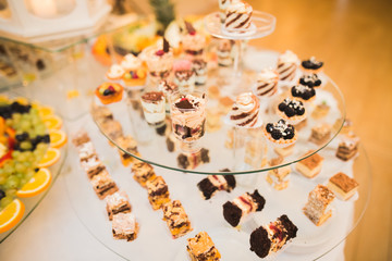 Delicious sweets on wedding candy buffet with desserts, cupcakes