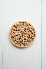 Hazelnuts in wooden bowl on white background