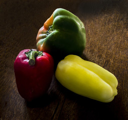 red green yellow peppers paprika on the wooden background