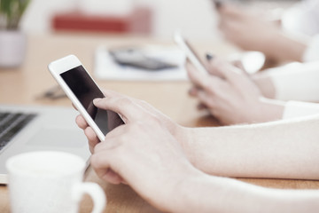 Millenials in young business office, meeting with smart phones