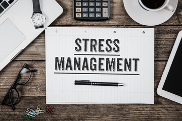 Stress Management statement on notepad on office desk from above