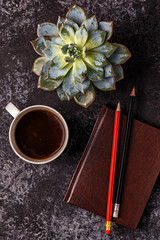 Table with notepad, flower and coffee.