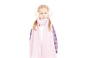 Portrait of little girl wearing scarf and winter ear muffs on white background