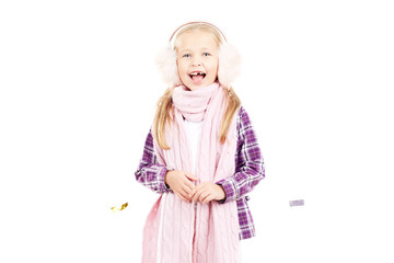Portrait of little girl wearing scarf and winter ear muffs on white background