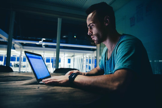 Young Businessman working late on his laptop in modern office