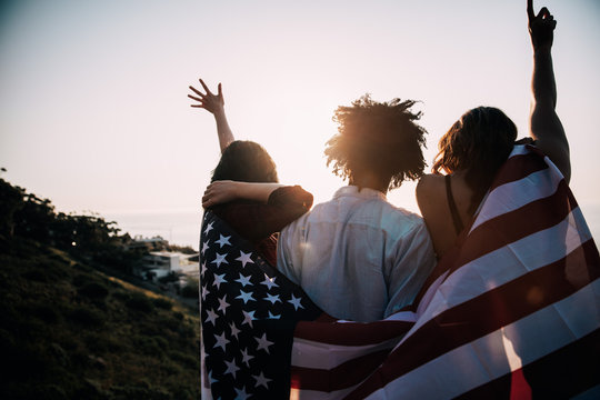 Group of millennial friends holding USA flag