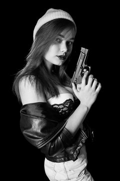 serious girl with gun on black background looking at camera, monochrome