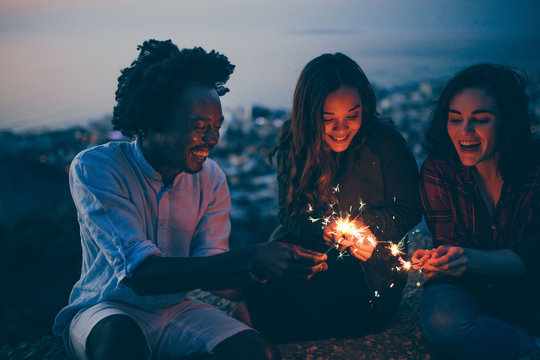 Mixed Race Group of young adults celebrating new years eve with sparklers