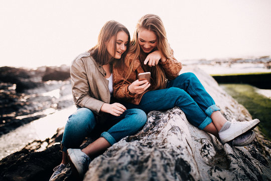 Happy Young teenager girls looking at smart phone and laugh