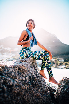 Mixed Race female athlete resting after workout at the beach