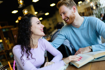 Young students spending time in coffee shop reading books