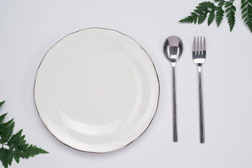 Dinner plate setting top view. Empty plate and silverware set on wooden table